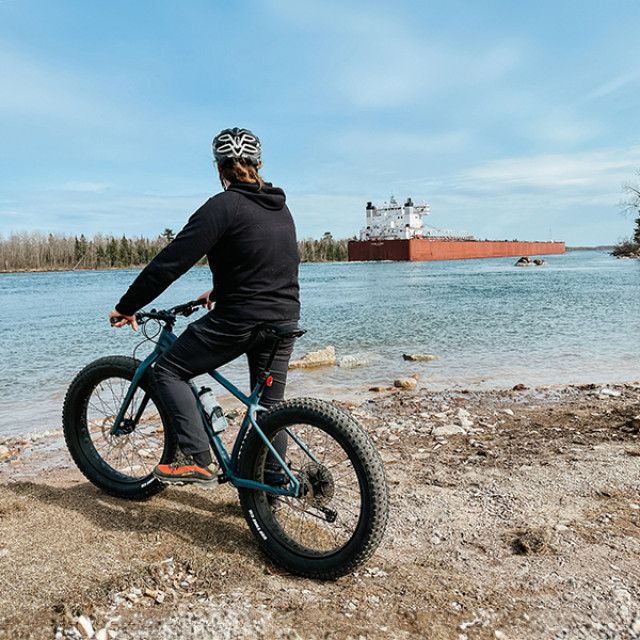 A biker watching a freighter come in at Rotary Island Park near Sault Ste. Marie, Michigan